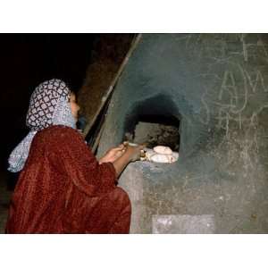Bedouin Woman Baking Bread in Mud Oven of Bedouin Camp, Luxor, Egypt 
