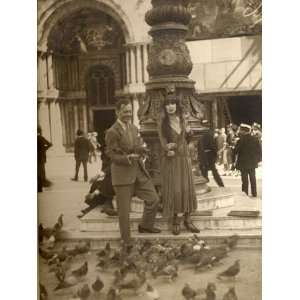  A Couple Feed a Flock of Pigeons at St Marks Basilica 